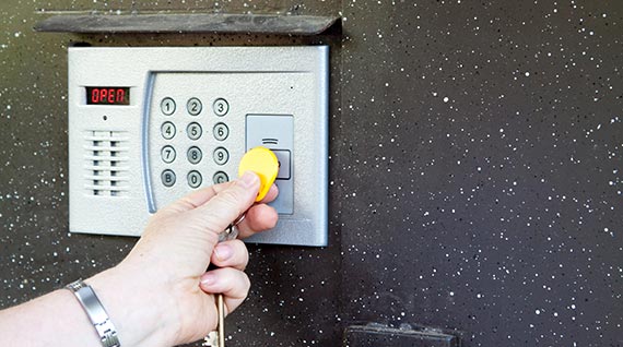 A person is holding a key to the door of a building.