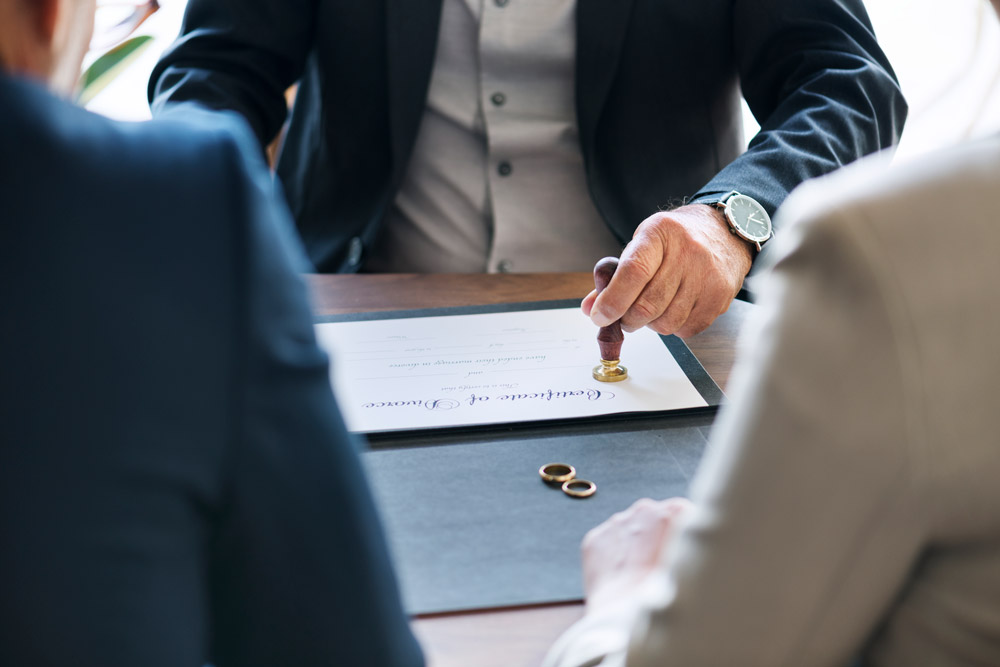 A man in suit and tie holding out his hand over a paper.